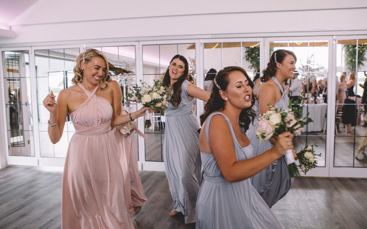 Bridesmaids dancing and singing as they make their grand entrance