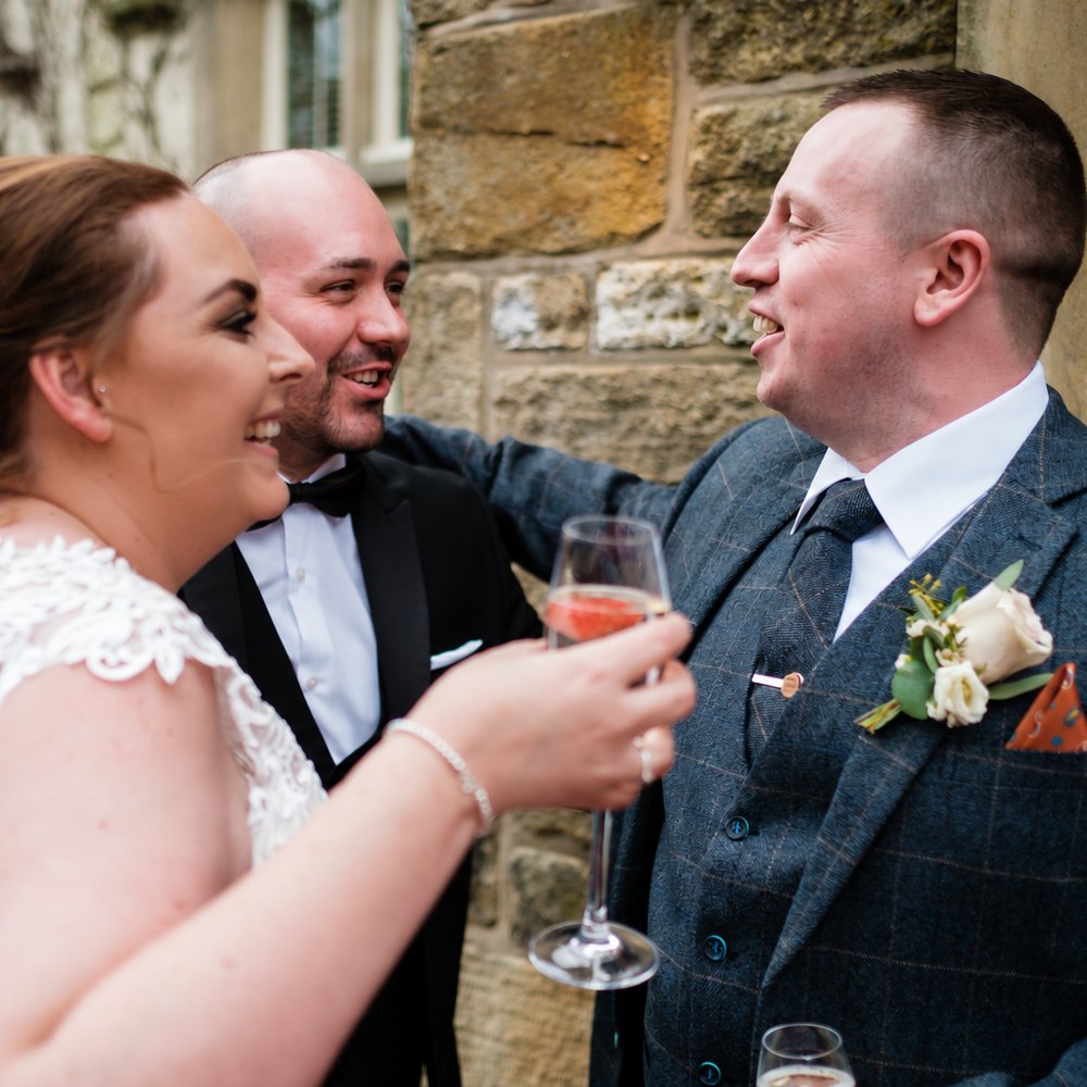 Chris laughing with Zoe and Mark over a glass of fizz outside Mitton Hall